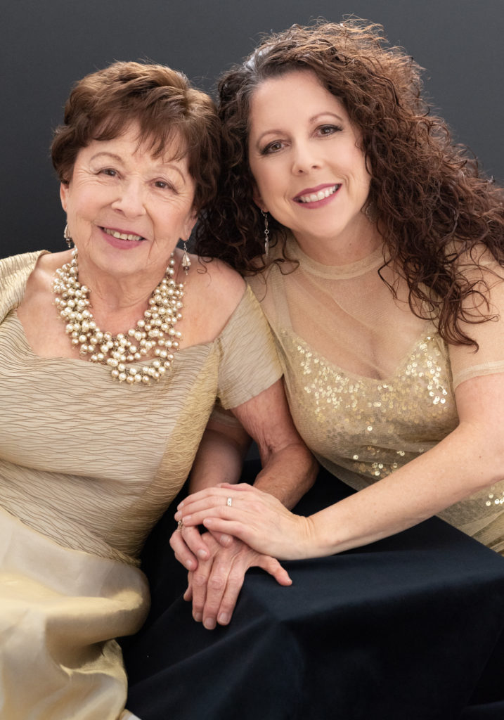 A mother in daughter dressed in gold dresses