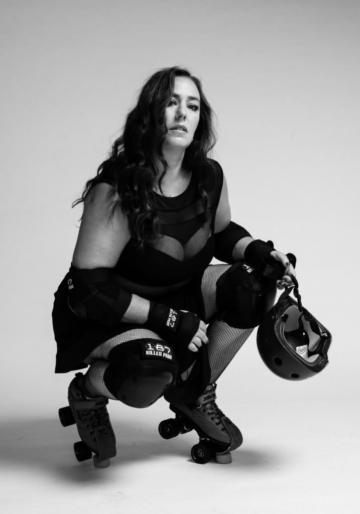 Gutsy, Gen X woman with roller derby gear in a black and white photo
