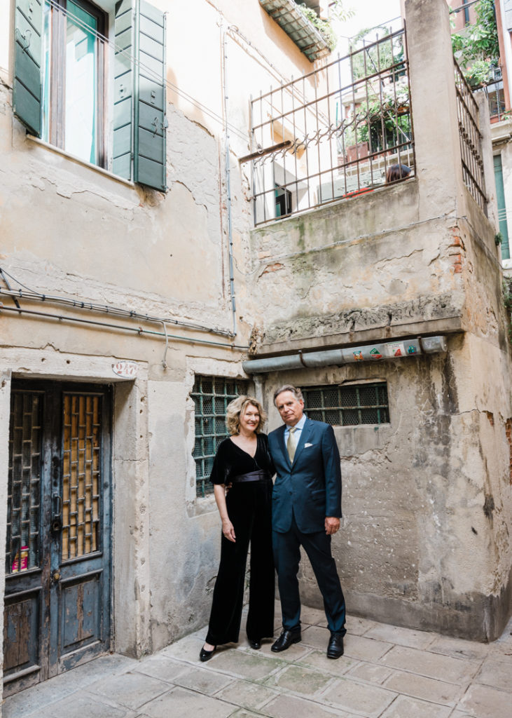 Newlywed couple in a small square tucked away in a far corder of Venice