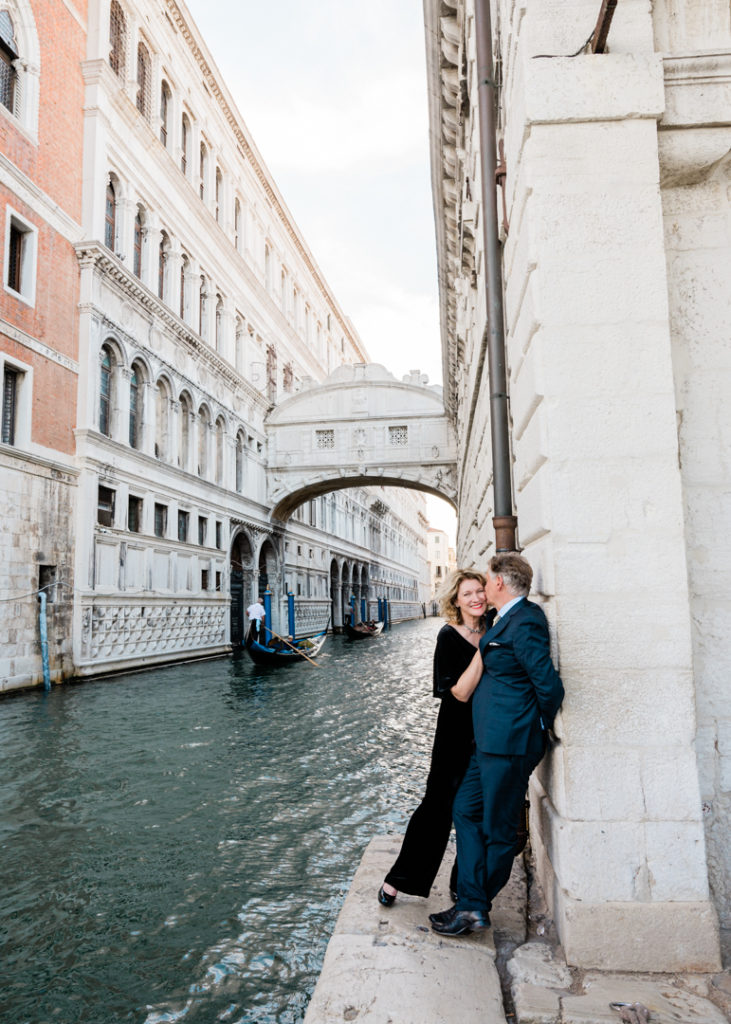 Newlywed couple looking at each other lovingly near the Bridge of Sighs, Venice 2022