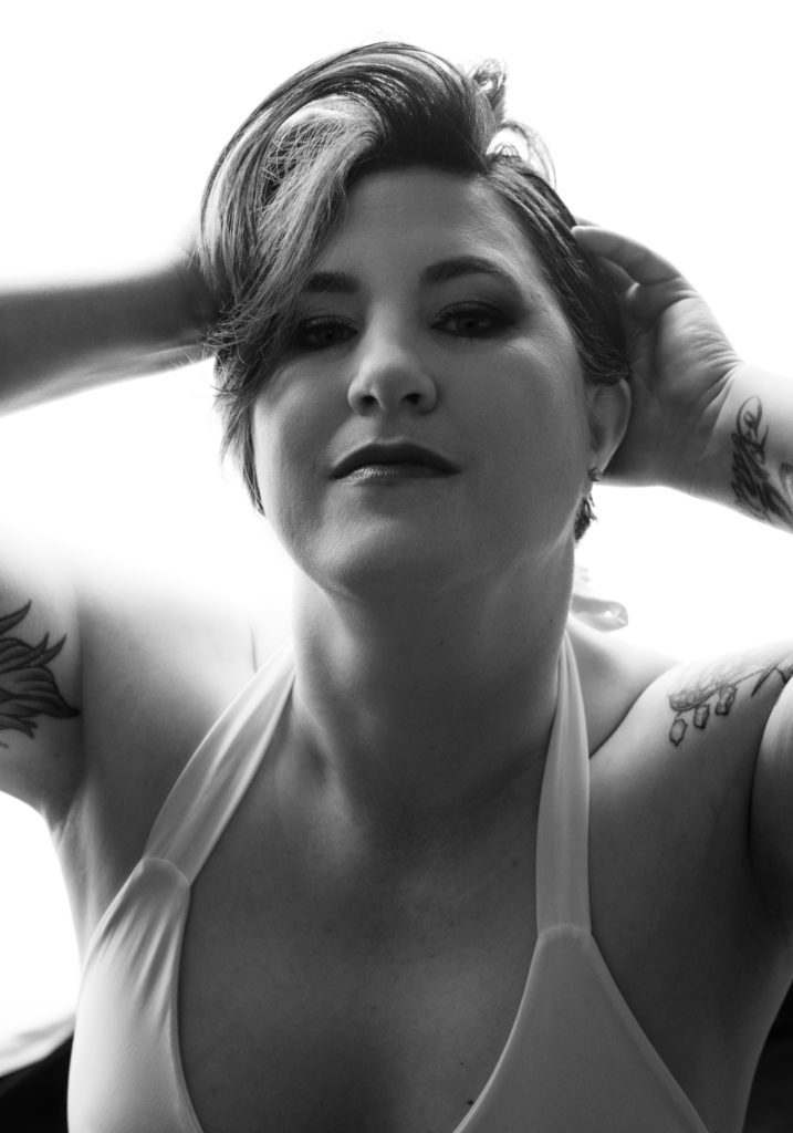 Portrait of a woman with tattoos gazing directly into the camera