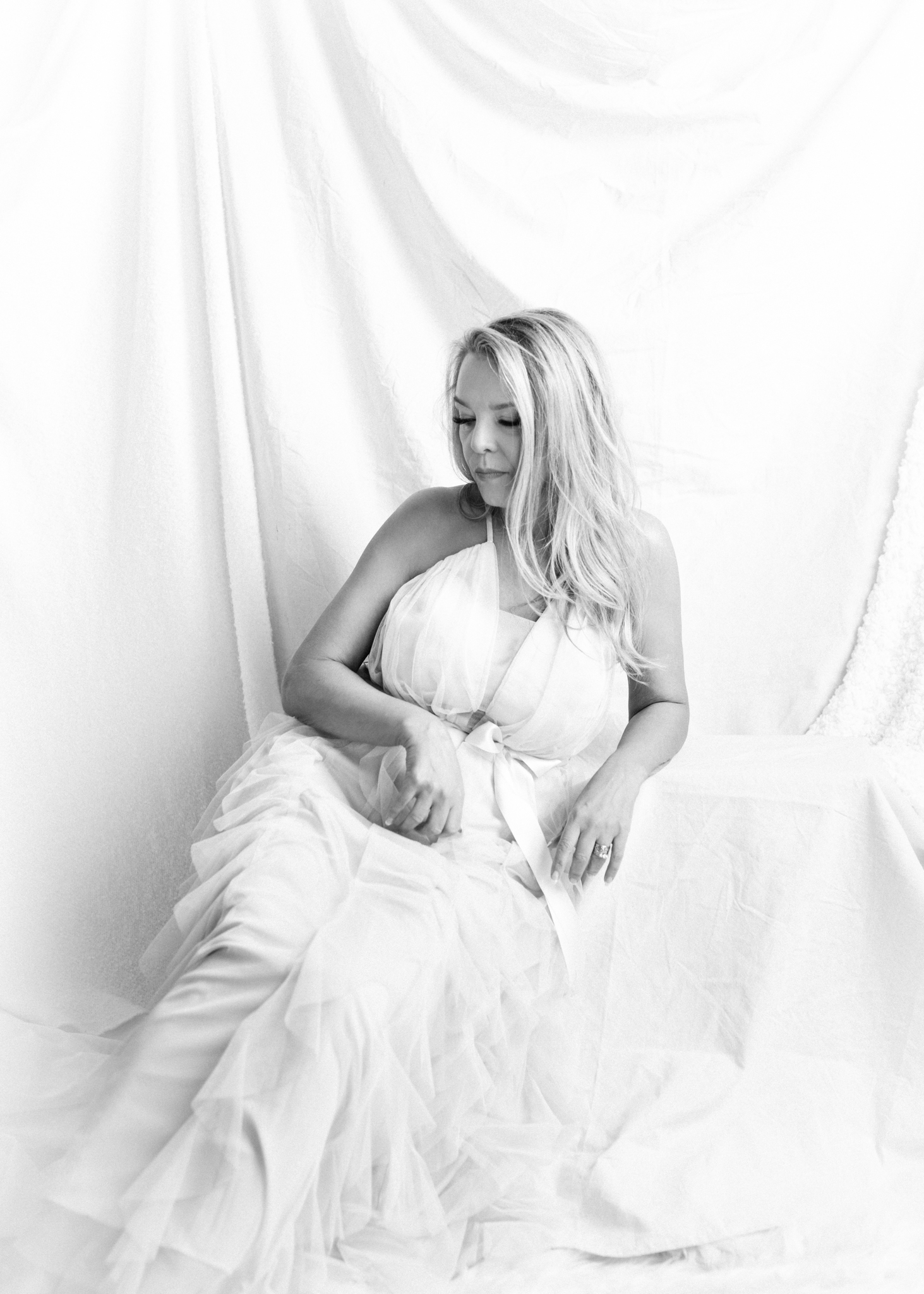 Blonde woman wearing white dress in a B&W photo